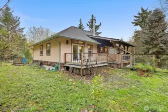 Backyard view highlighting the covered deck and serene private balcony