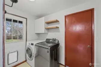 Laundry room, exterior side door, door to garage, and half-bath is to the cameras right.