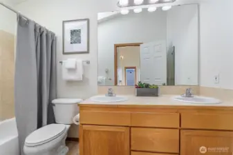 The top floor full bath with double sinks has vaulted ceilings and a skylight.