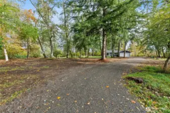 The private driveway, with lush trees, creates a serene entrance that feels like your own secluded sanctuary. Arriving home becomes a delight with the dramatic driveway—a beautiful path nestled in the woods that opens to a stunning, bright home. This hidden oasis offers the perfect blend of privacy and charm, making it an ideal retreat for everyday living and a wonderful space for hosting family and friends.
