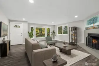 The home features expansive glass windows and doors, allowing an abundance of natural light to fill the space, even with trees on the property. The trees are set at a perfect distance—not too close to obstruct the view yet providing ample shade during sunny summers. Their beauty adds to the charm of the surroundings. The fireplace imparts a sense of coziness, warmth, and positive energy. The open, airy, and easy flow of this family room is ideal for both daily living and entertainment. Canned lighting adds bright, non-glaring light, enhancing the overall ambiance. Luxury Vinyl Plank flooring adds beauty.
