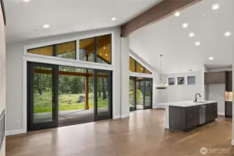 Large kitchen island and dining area with ornate chandelier.