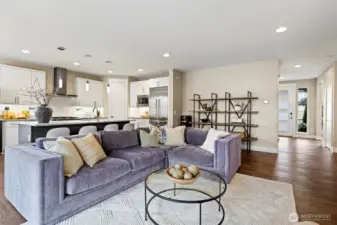 Large great room with high ceilings and grand chef's kitchen. Gas Fireplace, custom mounted TV, floor to ceiling tile surround.