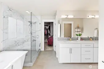 Spa inspired primary bath with large shower, soaking tub, and grand walk-in closet.