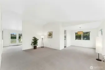 Step inside to a welcoming living area, with the dining space to the right and views of the expansive backyard through the French doors.