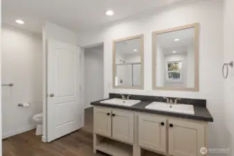 The private bathroom off the primary room has a double sink vanity.