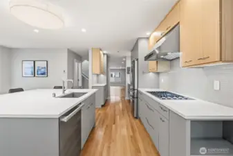 Chef’s kitchen with steam oven, gas cooktop, and a powerful vent hood.