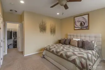 Spacious primary suite is large enough for the largest of furniture.  Hallway leads to a walk-in closet and bath.
