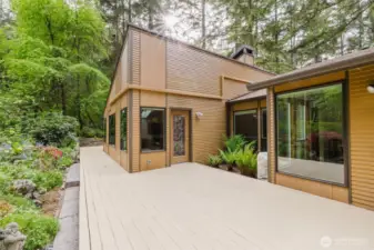The expansive patio wraps around the rear of the home, offering multiple entrances that seamlessly connect the indoor and outdoor spaces...