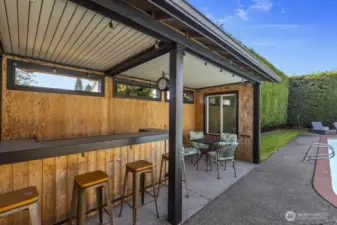 A pool house with bar seating and table space keeps the party going all day long.