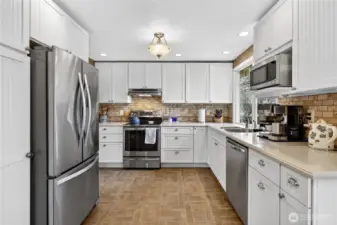 Abundant real wood Schrock cabinets, cupboards and drawers. Corian bullnose countertops with Travertine tile backsplash