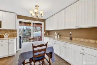 DINING SPACE  Built in 10’ long wall-to-wall buffet    Schrock Whittaker wood beadboard shaker design upper and lower cabinets  Corian bullnose countertop and Travertine tile backsplash  Slider with screen door to rear covered 6’x8’ deck with Pergola