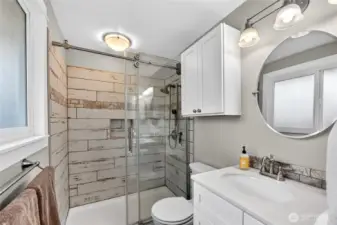 PRIMARY ¾ BATHROOM – Remodeled 2018  Wood Shaker style cabinets with Quartz countertop and undermount sinks  Shower with Silver Travertine surround, barn door, double shower head & shampoo cubby  Ceramic floor barn tile