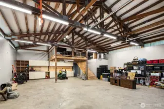 Now that's a SHOP -- note heater up above, Room to the right of the stairs was used for storage but could be converted to a bathroom.  (well house is very close to shop) Steps up to loft area and more storage.