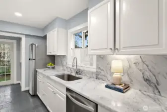 Galley kitchen off of the Formal Dining room enjoys beautiful Carrara Marble counters and backsplash with stone floors.