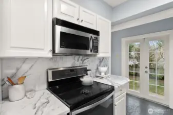 French doors off of kitchen open to deck and fenced, level back yard!