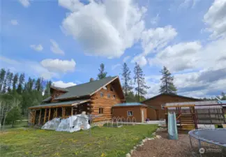 Back of house with more wood storage and gardening space close to play area