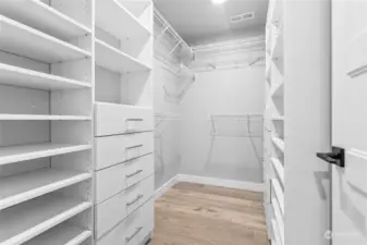 Large, primary closet with closet organizers.