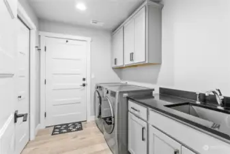 Large laundry room with entry to garage, near primary bedroom.