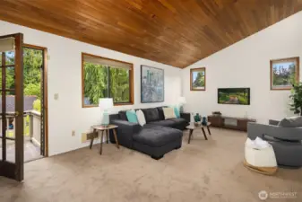 Upstairs family room with vaulted ceiling, and door to the upper deck overlooking the backyard.