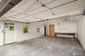Spacious garage with workbench and storage space.