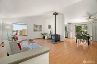 Front entry way looking into living room with large windows and wood burning stove