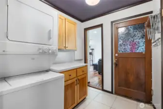utility room with stackable unit, built-in cabinets and folding space