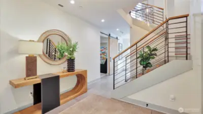 From the moment you enter, you're greeted by a dramatic custom staircase and three-story cascade of pendant lights, setting the tone for the home's sophisticated ambiance.