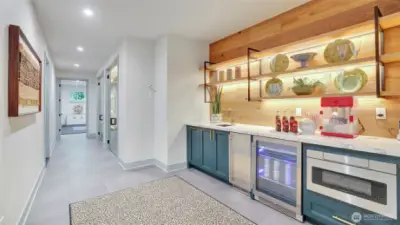 A stylish café bar with mini-fridge, icemaker, microwave and ambient lit floating shelves adds convenience.