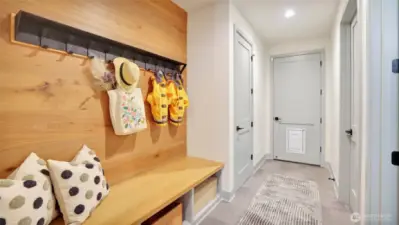 Mud room with bench, cubbies and hooks for clothing at the garage entry, enhances everyday living.