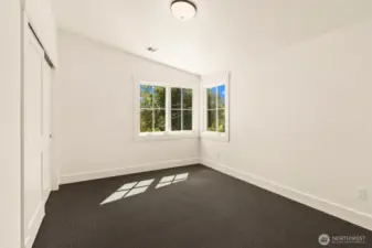 SE corner guest bedroom upstairs with vaulted ceilings.
