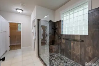 Custom walk-in shower with glass block window. Large linen on the left.