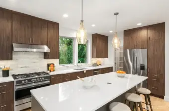 Under cabinet lighting, counter-depth fridge, & stylish pendant lights are a nice touch.