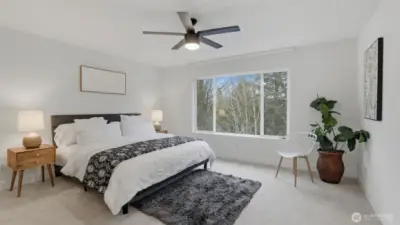 Spacious primary bedroom with large window and soft natural light.