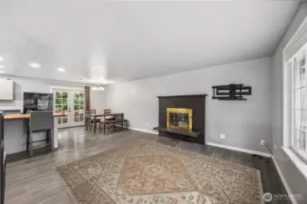 Living room with cozy fireplace and large windows bringing in natural light.