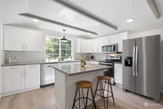 Kitchen with spacious island creates room for seating, extra cabinet storage space and additional countertop workspace.