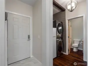 Then entry opens to the unit with tile floor. On the left is the utility area and on the right is the secondary bedroom.