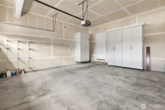 The garage offers shelving and cabinet storage.