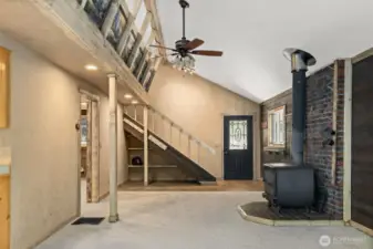 Living room with a wood burning stove, notice the helmet underneath the stairs?  Great storage for your winter gear!