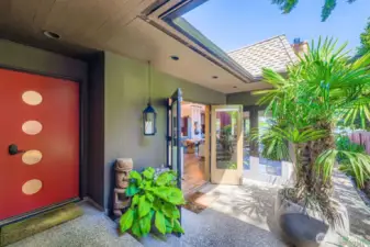 Side main entry door (red) and side French doors. Sidewalk path wraps around to the 60' of lake frontage.