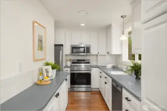 The bright and cheery kitchen boasts newly painted cabinets, new backsplash, new fridge and microwave.