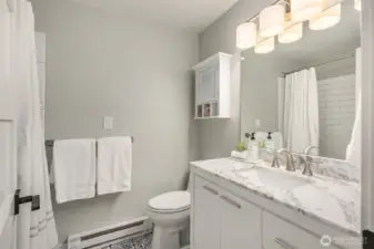 Second full bathroom in the lower level features a large vanity with a spacious marble countertop and lots of storage.
