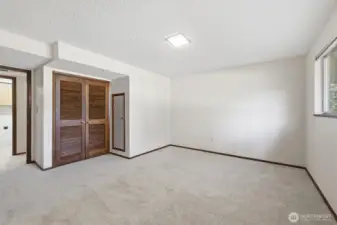 2nd photo of lower large bedroom standing in front of built ins.