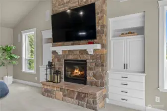 Floor to ceiling fireplace with beautiful stone surround and built in shelving.