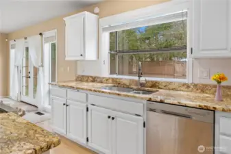 Granite counters, freshly painted cabinets, dual sinks, and a view to the private courtyard are some of the wonderful features in the spacious kitchen.