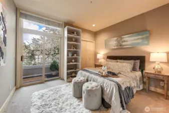 Guest bedroom with view of flowering cherry tree and slider to balcony.