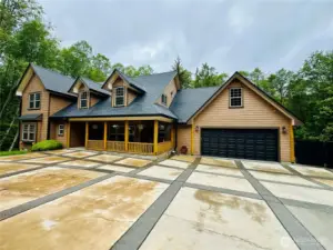145 Scenic Lane with covered front porch and covered deck provide a the PNW feel with sounds of the creek and lushes evergreens skirting the grounds.