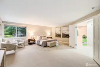 Upstairs, the indulgent primary suite is a true sanctuary. French doors open to a serene retreat with space for a full king set and a cozy sitting area. Expansive corner windows frame views of the meticulously landscaped backyard, filling the room with soft, natural light.