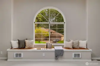 Huge window seat with storage space overlooks gorgeously manicured front yard.