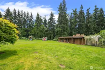 Sprawling lawns and gardens with old west style storage sheds conveniently located in rear yard.